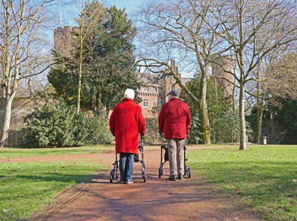 Senioren mit Rollator laufen durch den Burgpark